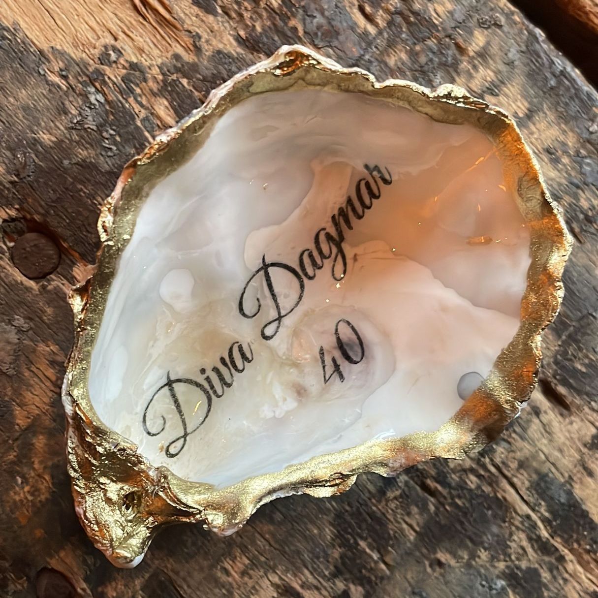 Oesterschelpschaaltje met gouden rand, met de tekst 