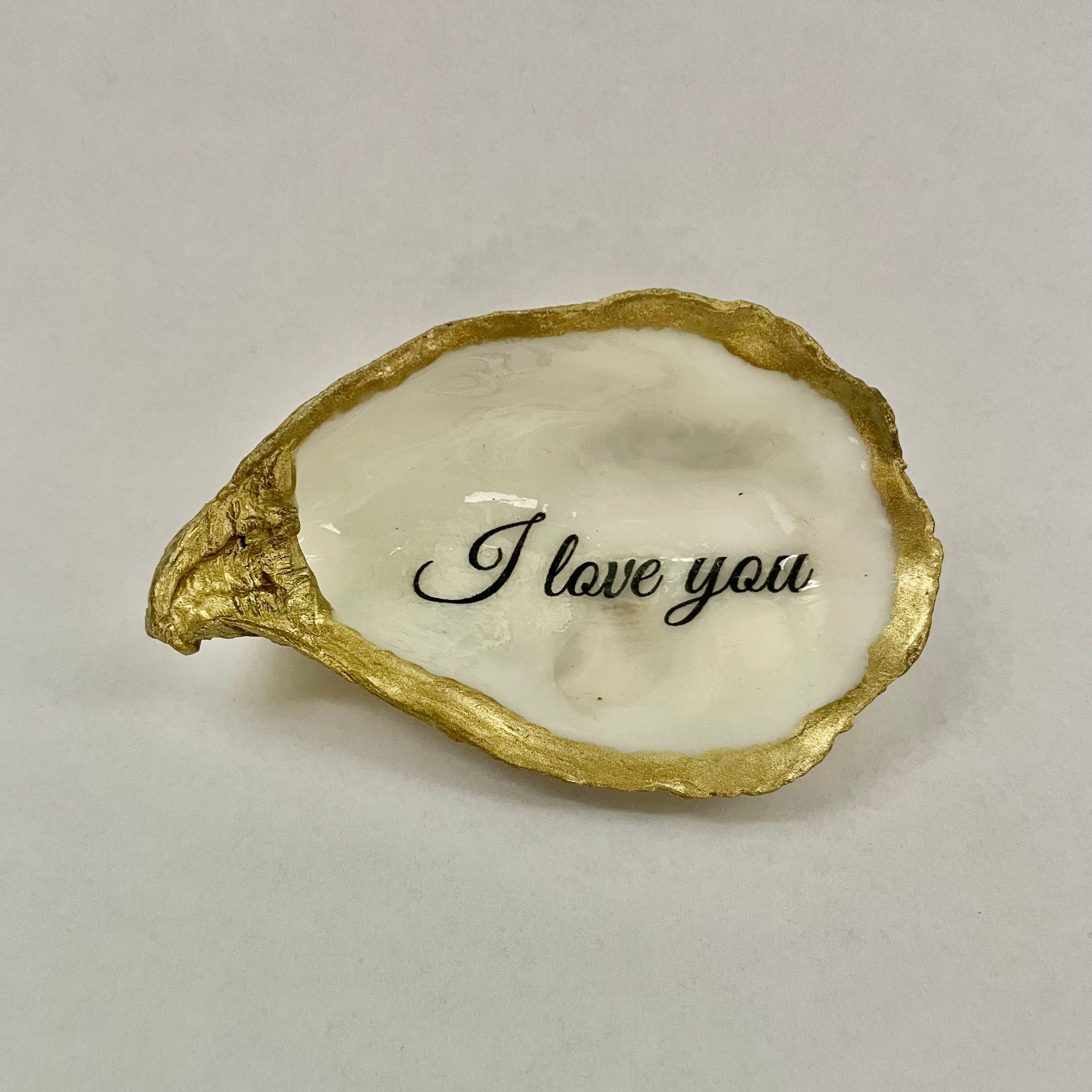 Sieradenschaaltje van oesterschelp met gouden rand en de tekst: I love you