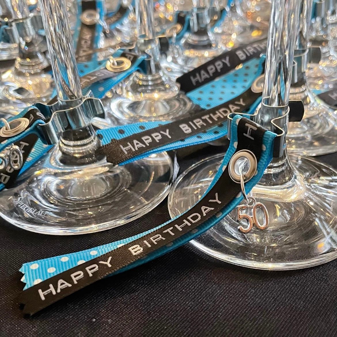 blauw en zwarte linten met de tekst happy birthday met metalen klemmetjes
