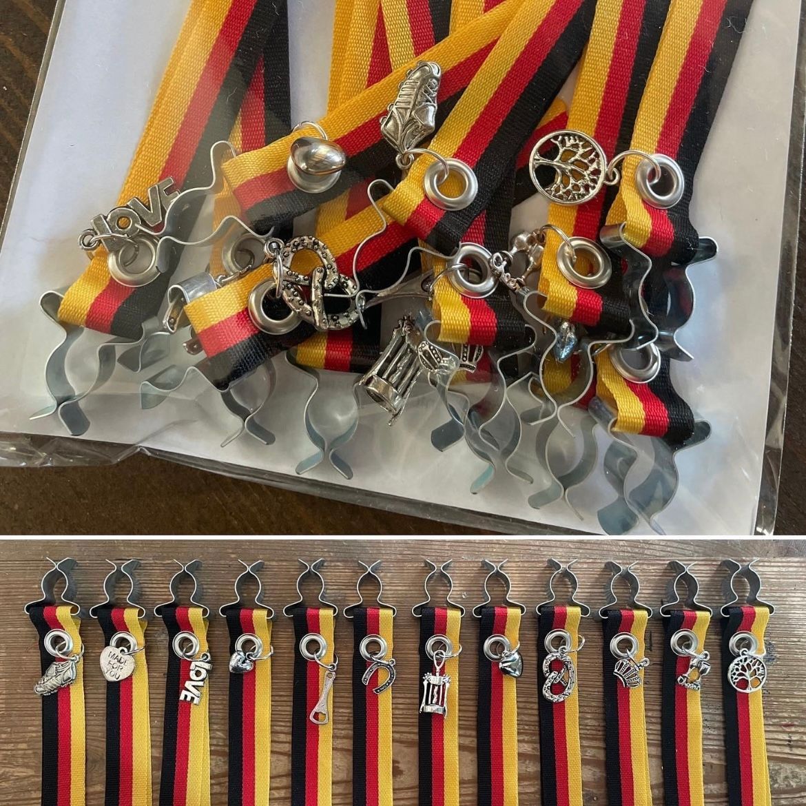 Lintenmet zilveren bedeltjes. De linten zijn zwart, goud en rood. Met zilveren clips en bedeltjes eraan bevestigd.