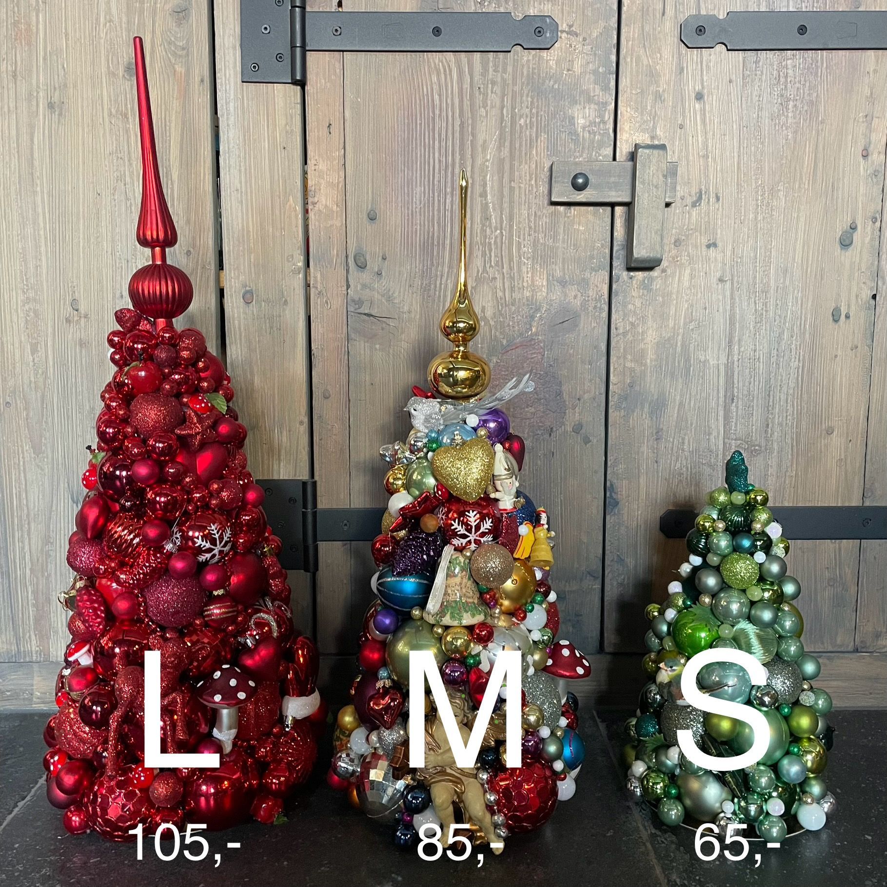 Drie kerstboomversieringen, rood, veelkleurig en groen, tentoongesteld tegen een houten achtergrond.