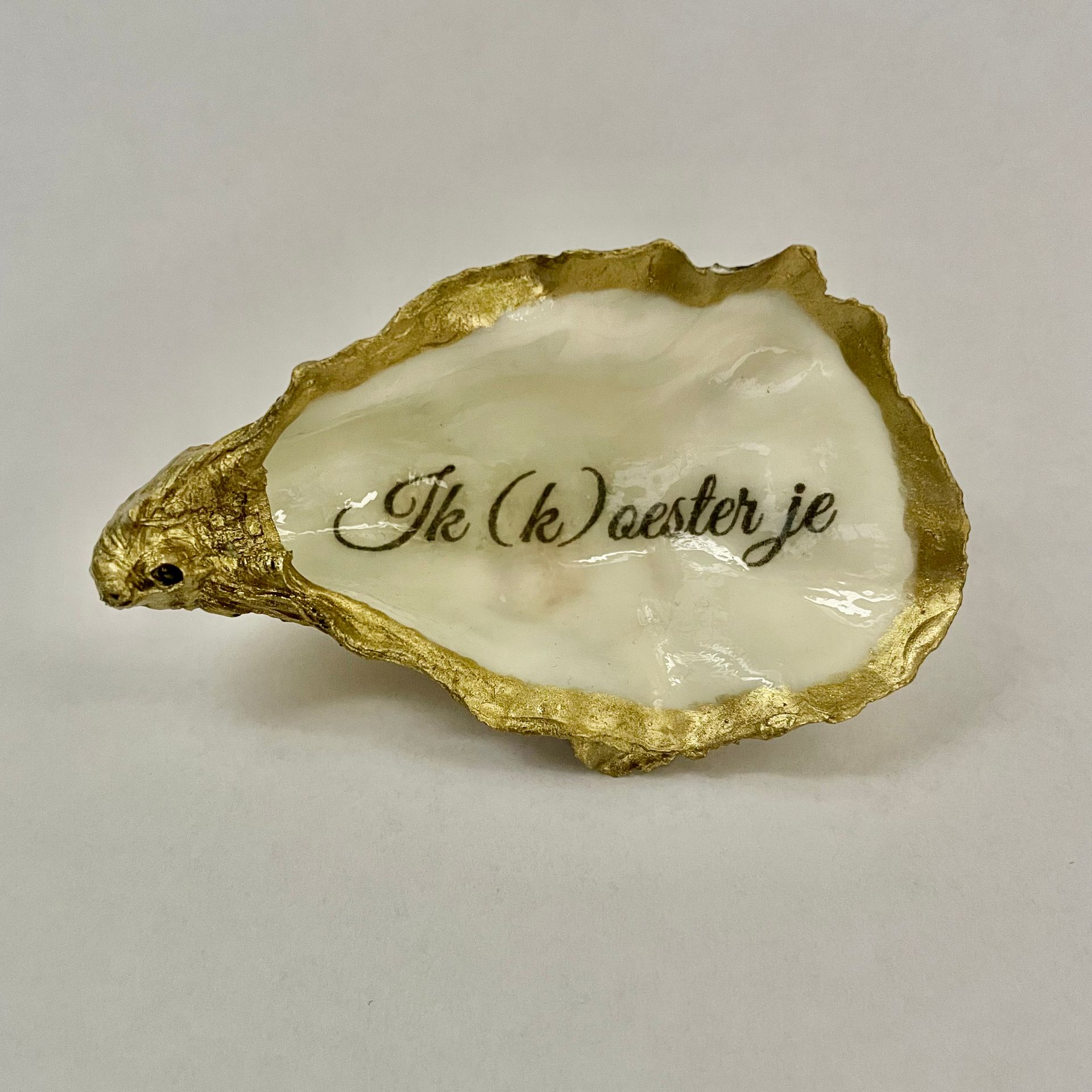 Oesterschelp, goud geverfd, met opschrift: Ik (k)oester je