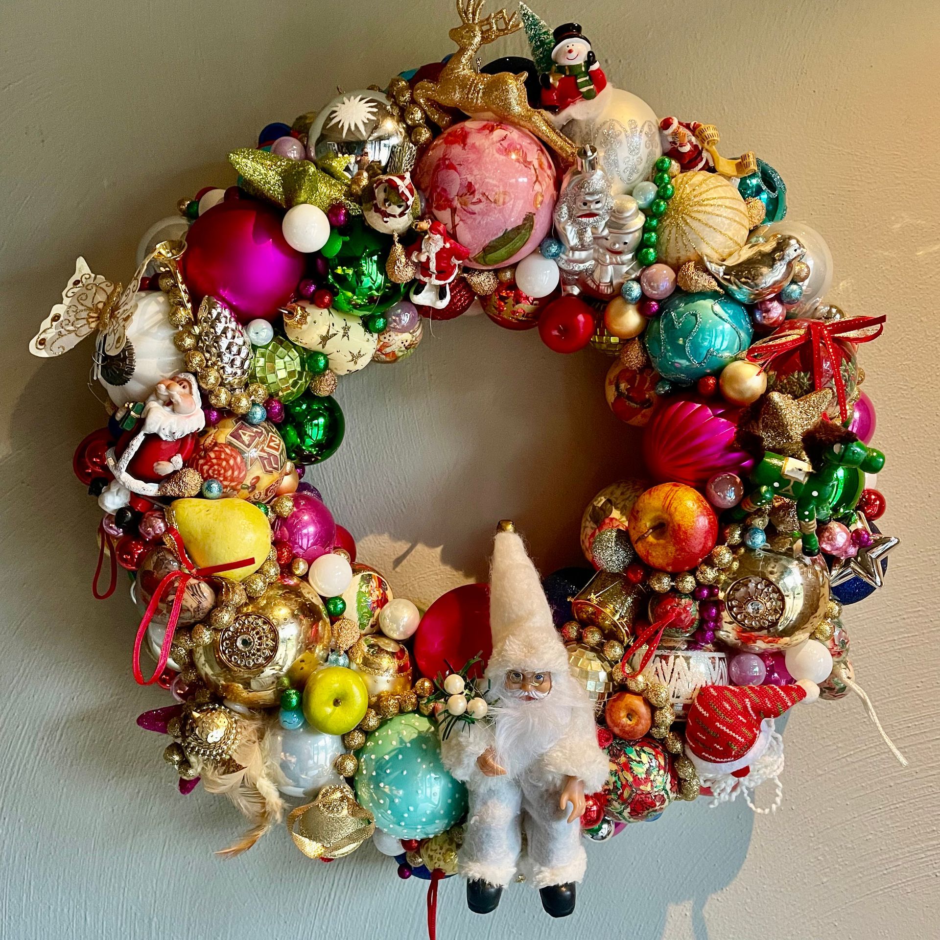 Kerstkrans met kleurrijke versieringen en een kerstmanfiguur.