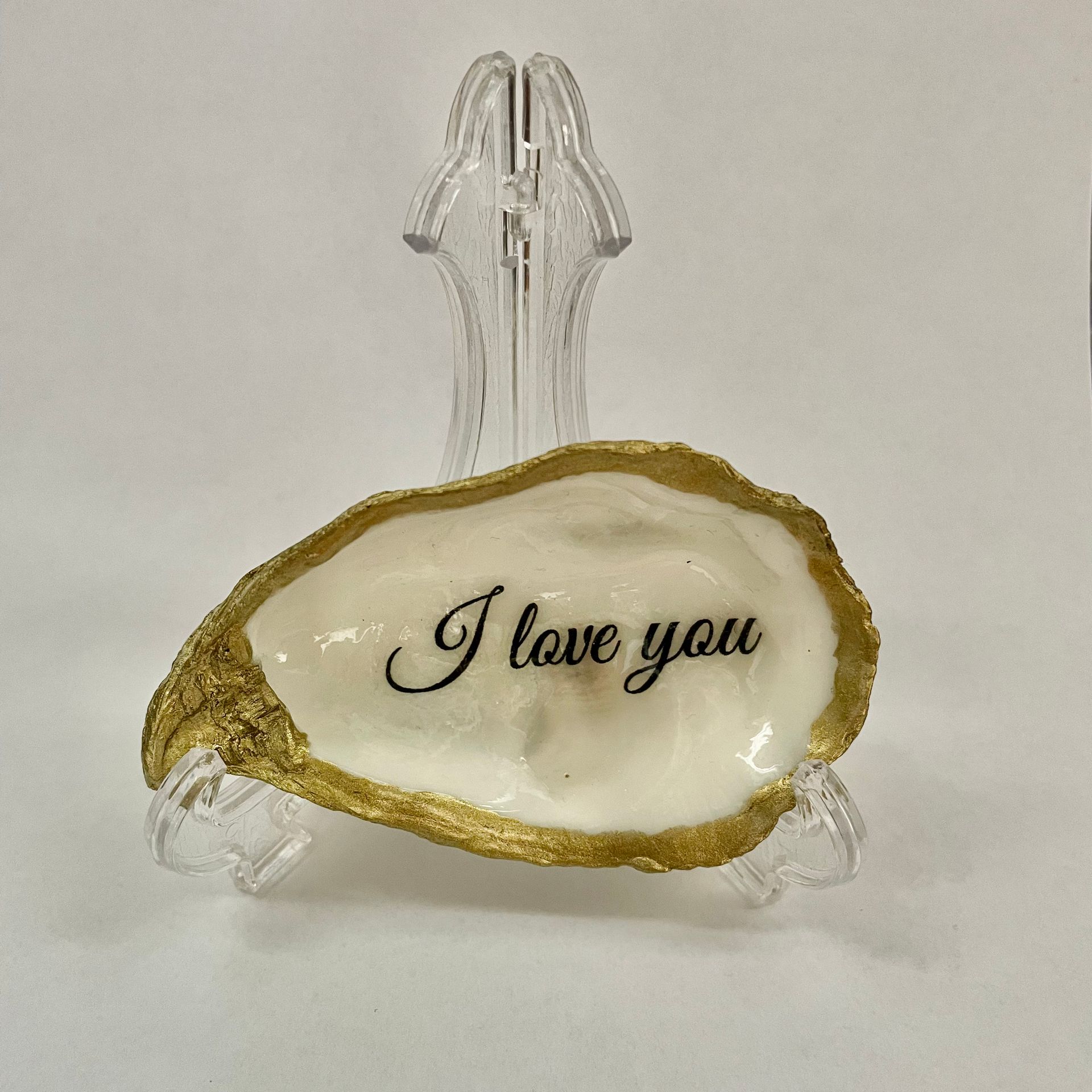 Een oesterschelp met gouden rand en de inscriptie I Love you