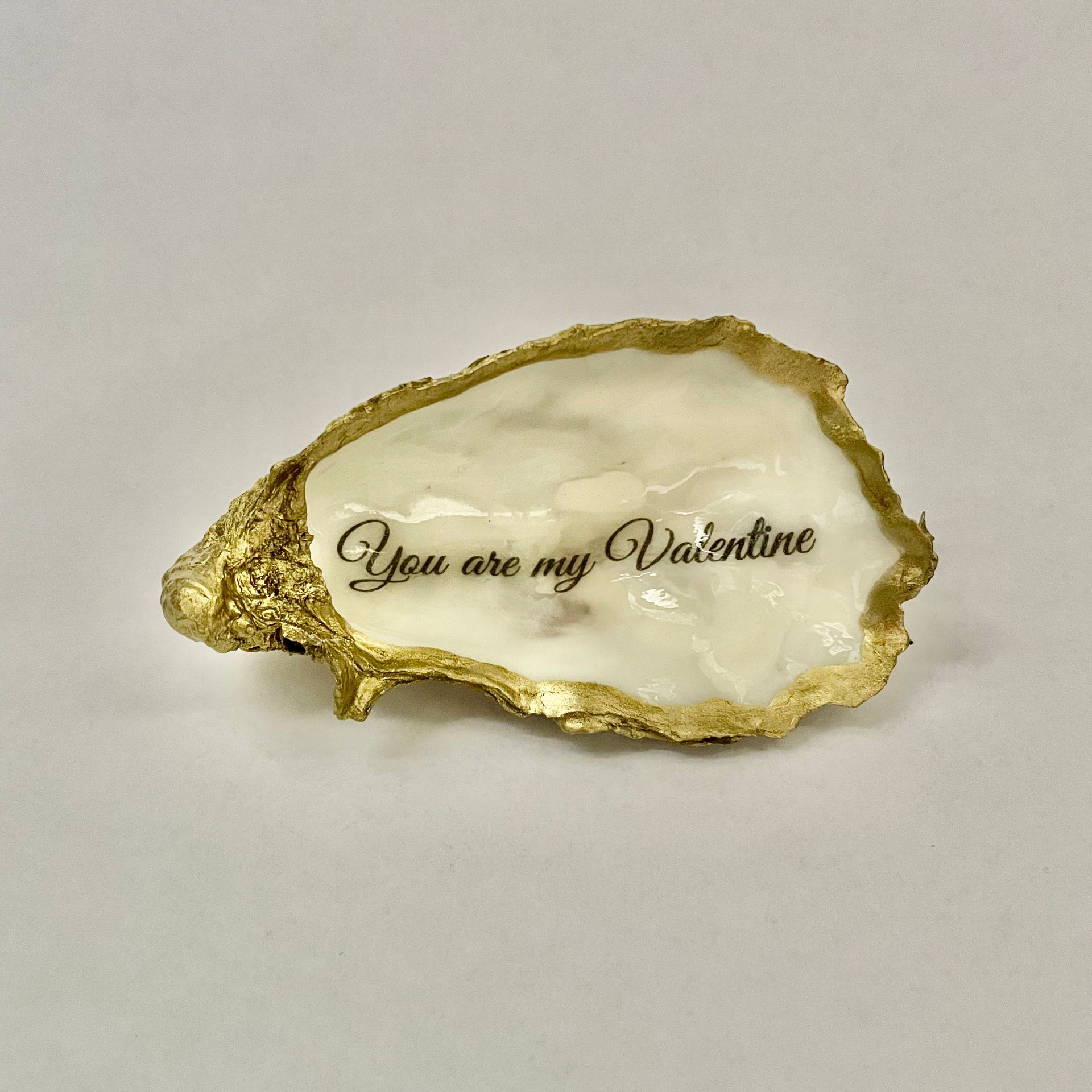 Een met goud beschilderd sieradenschaaltje in de vorm van een oesterschelp met de tekst: You are my valentine