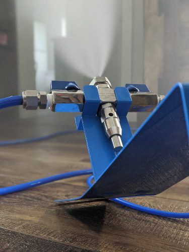 Close-up of a blue metal and tubing connector assembly on a wooden table