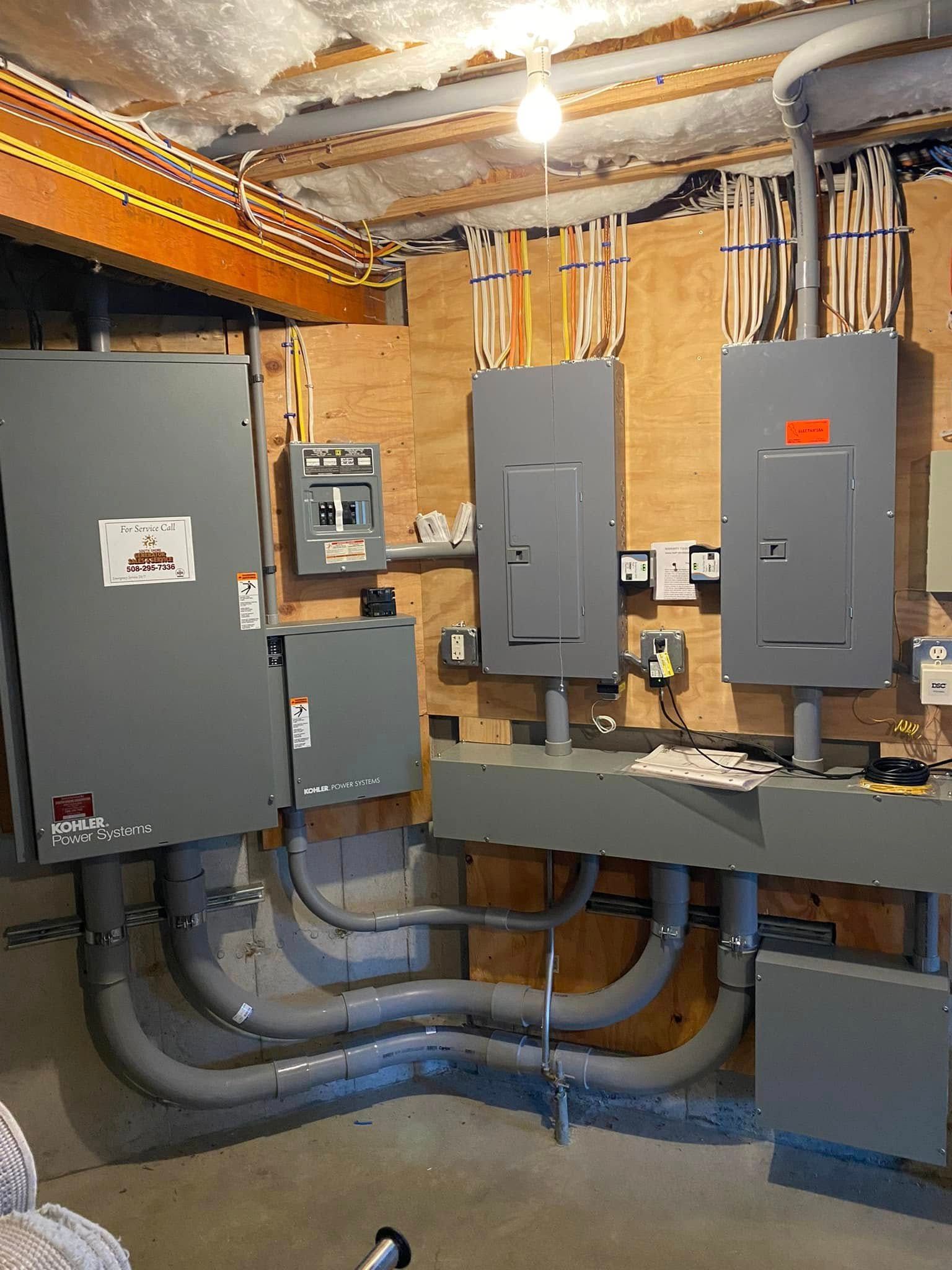 Electrical panel room with gray breaker boxes, conduit pipes, and exposed ceiling wiring.
