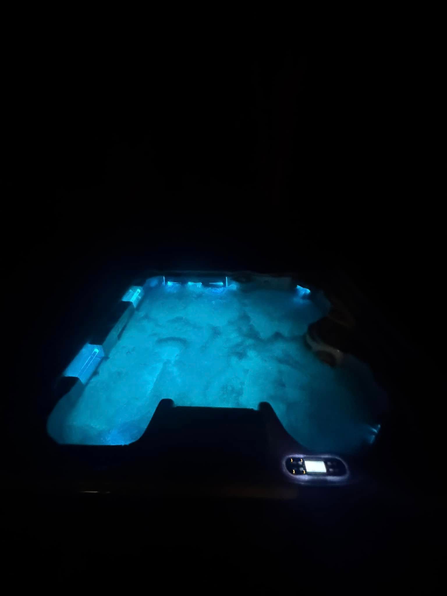 Blue-lit cave or tunnel interior at night, with a small illuminated vehicle at the bottom right.