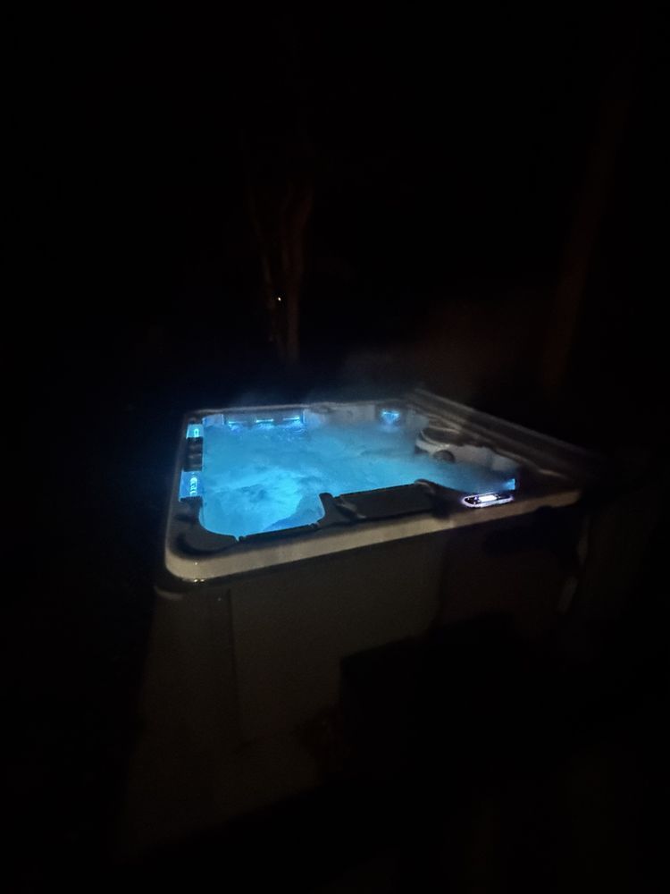 Blue-lit tabletop device in a dark room, with steam rising from its surface.