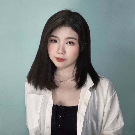 一位留著及肩黑髮的女子，身穿白色襯衫，內搭黑色上衣，背景則是淺藍色背景。
