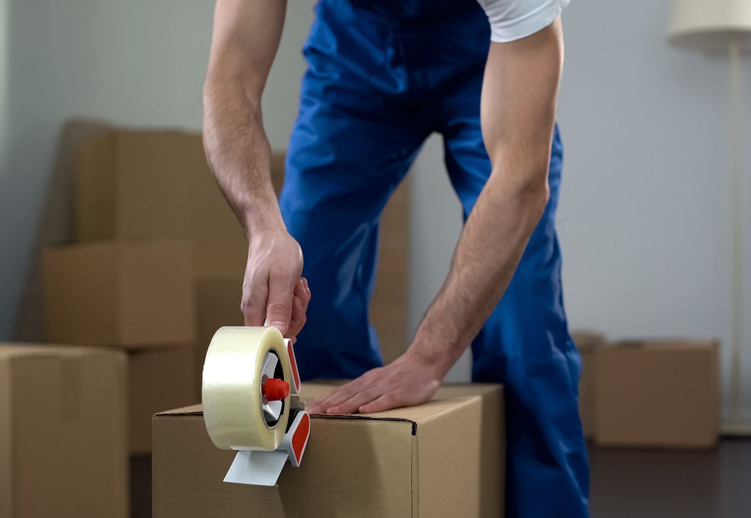 Worker sealing a cardboard box with packing tape