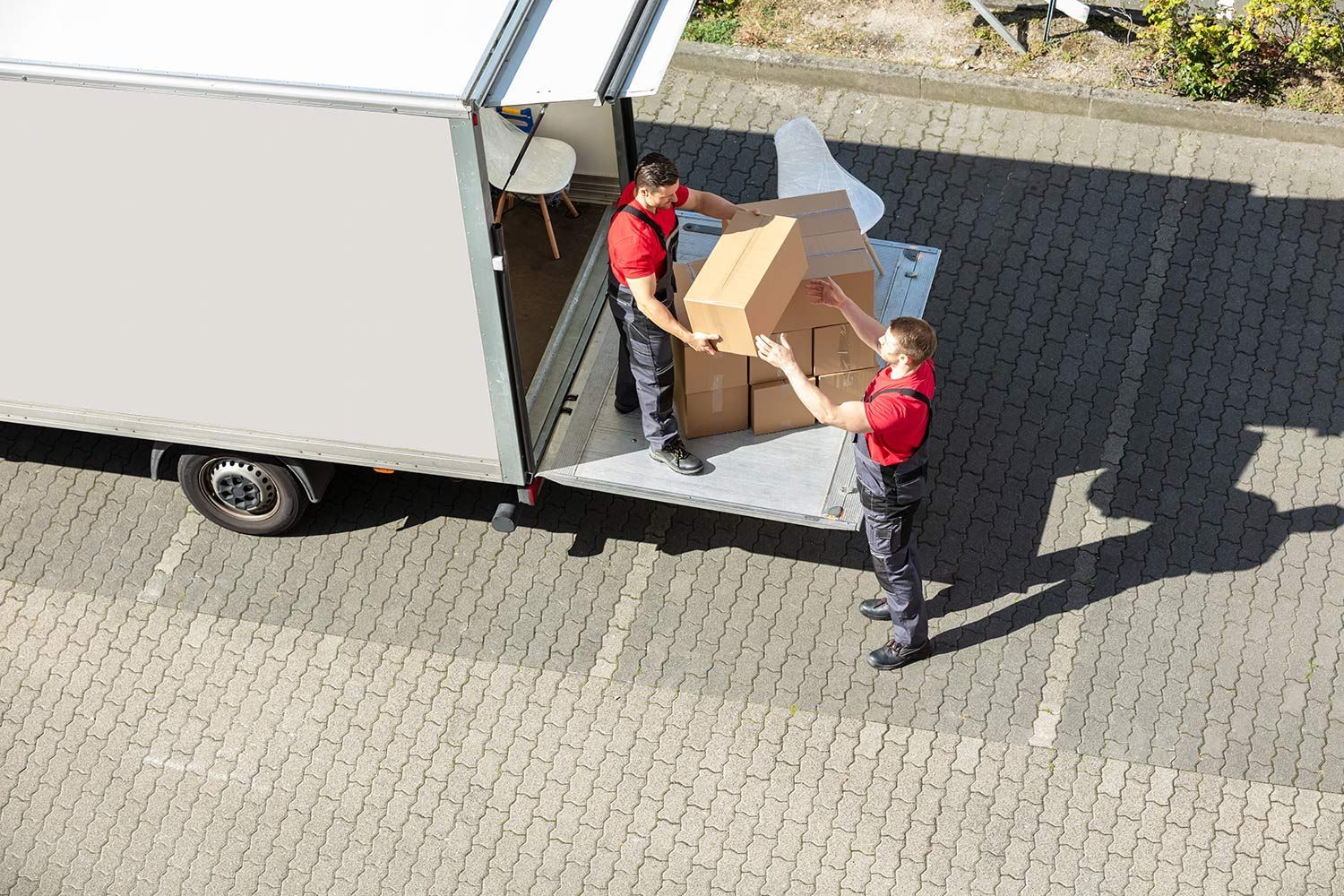 Workers loading boxes into a white truck