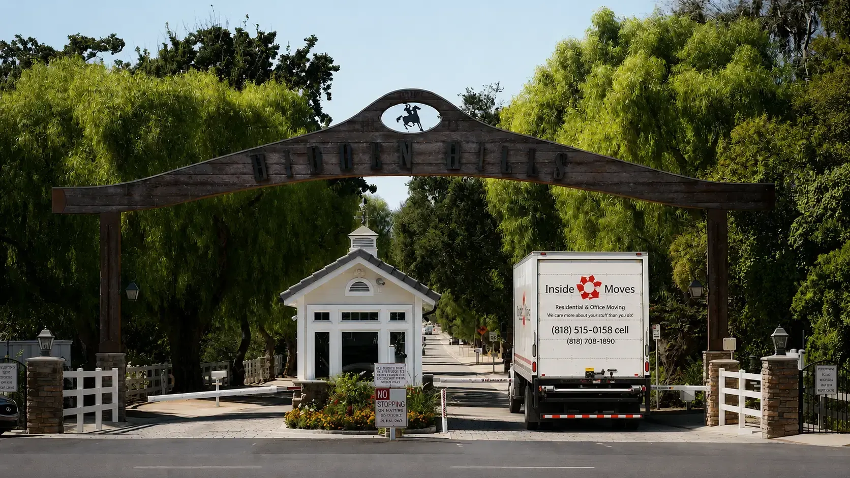 Gated entrance with stone arch and a white truck