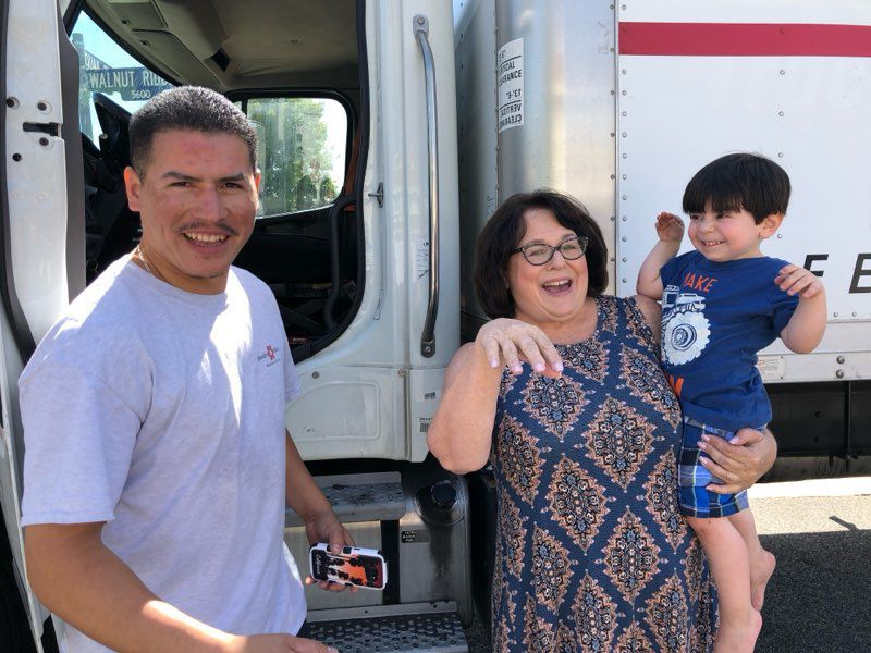 People smiling beside white truck
