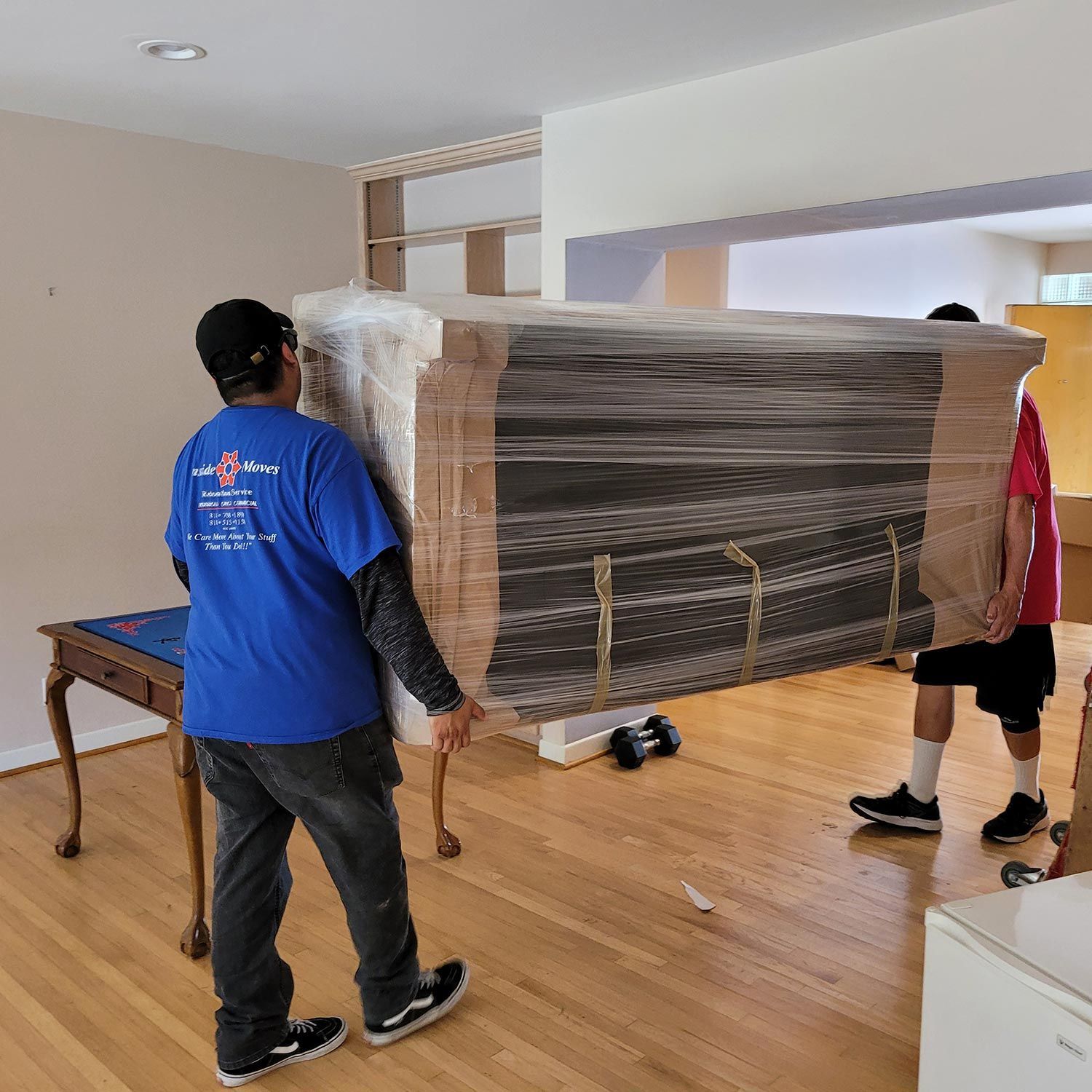 Workers carrying a wrapped sofa