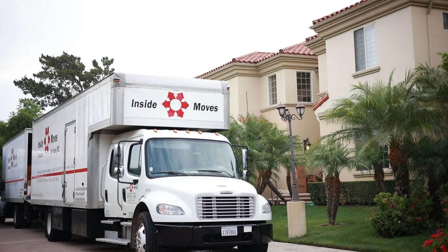 White moving truck parked outside a house