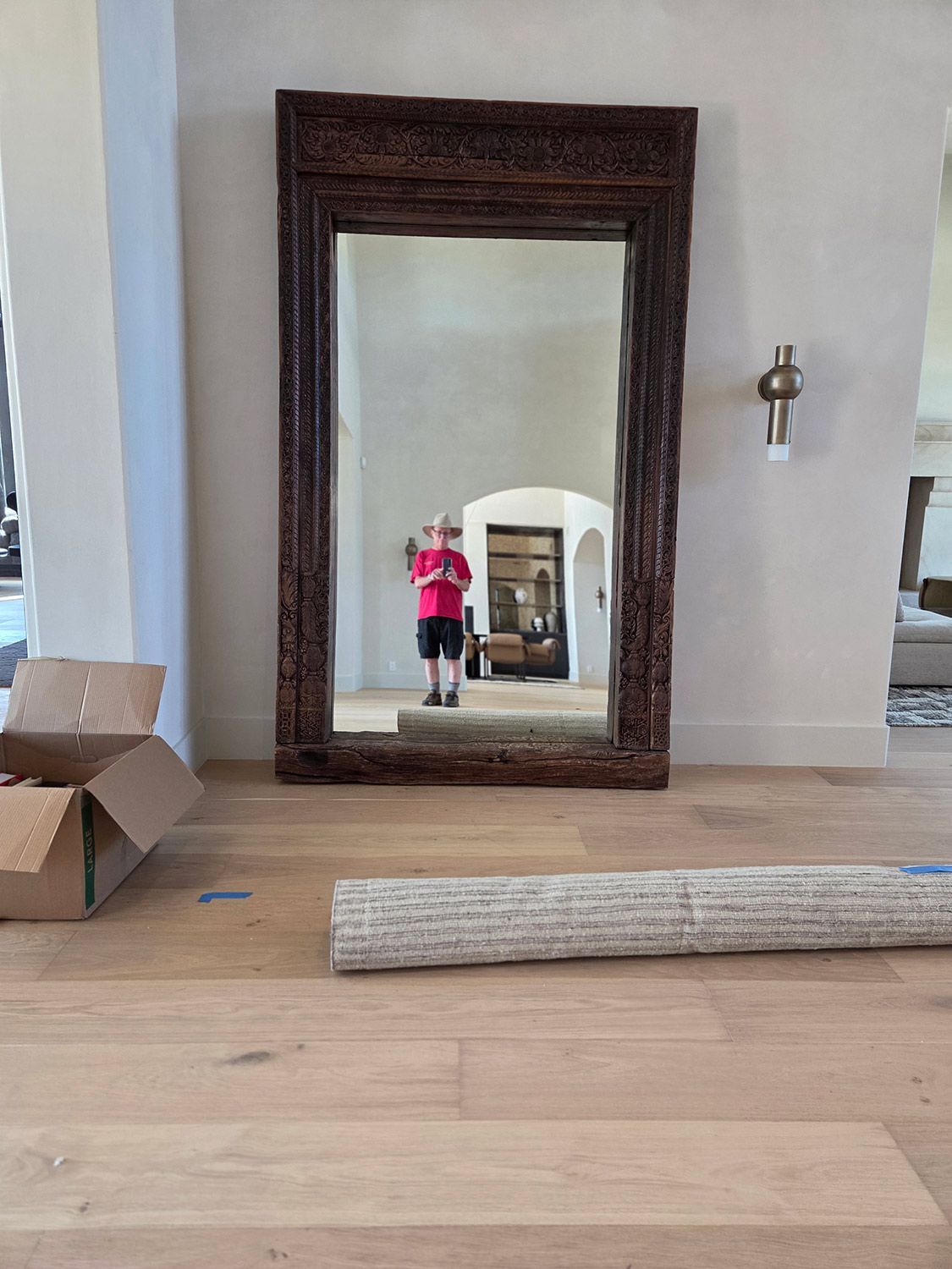 Living room with a large ornate mirror reflecting a person
