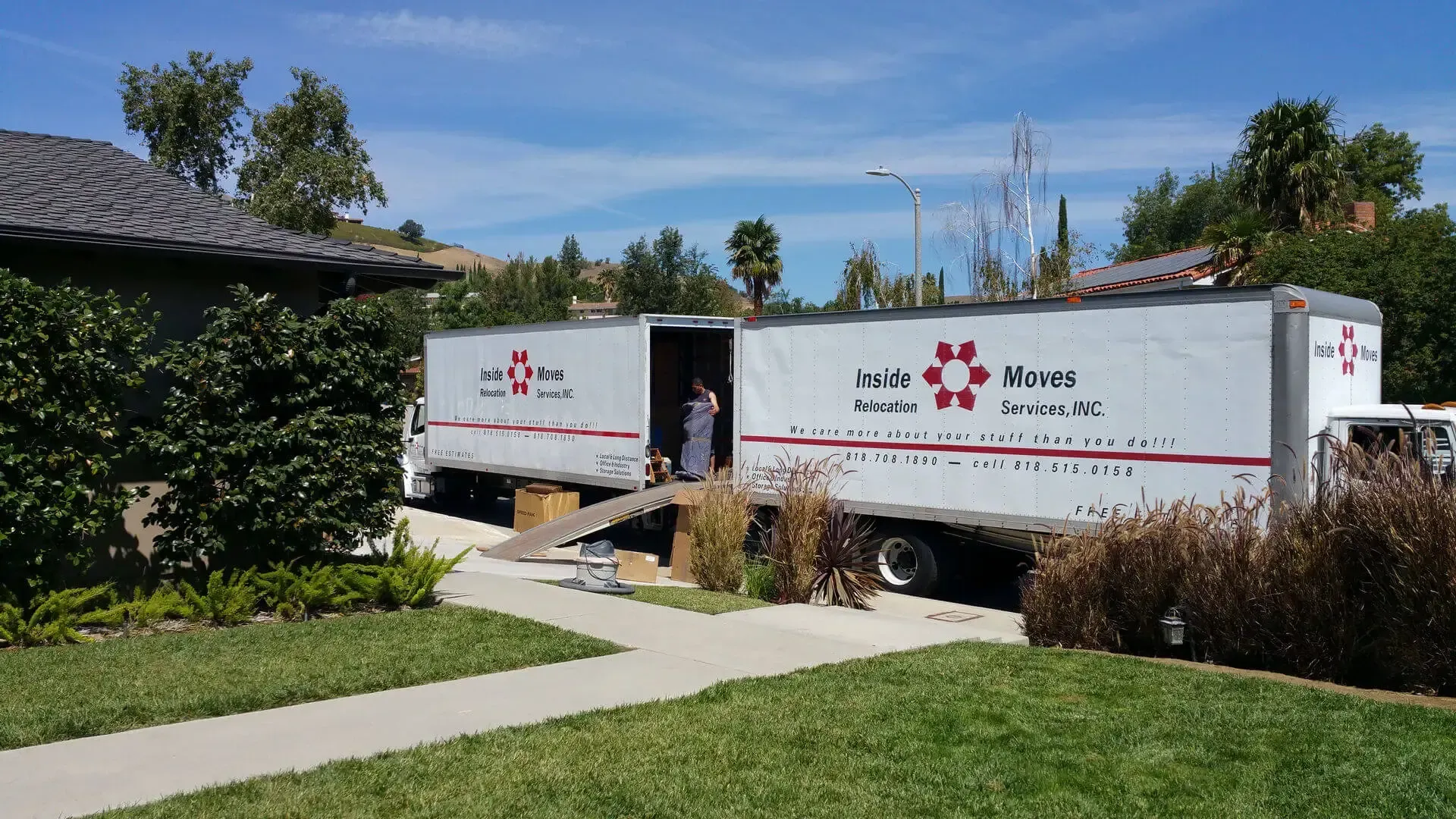 Two white moving trucks parked on a driveway