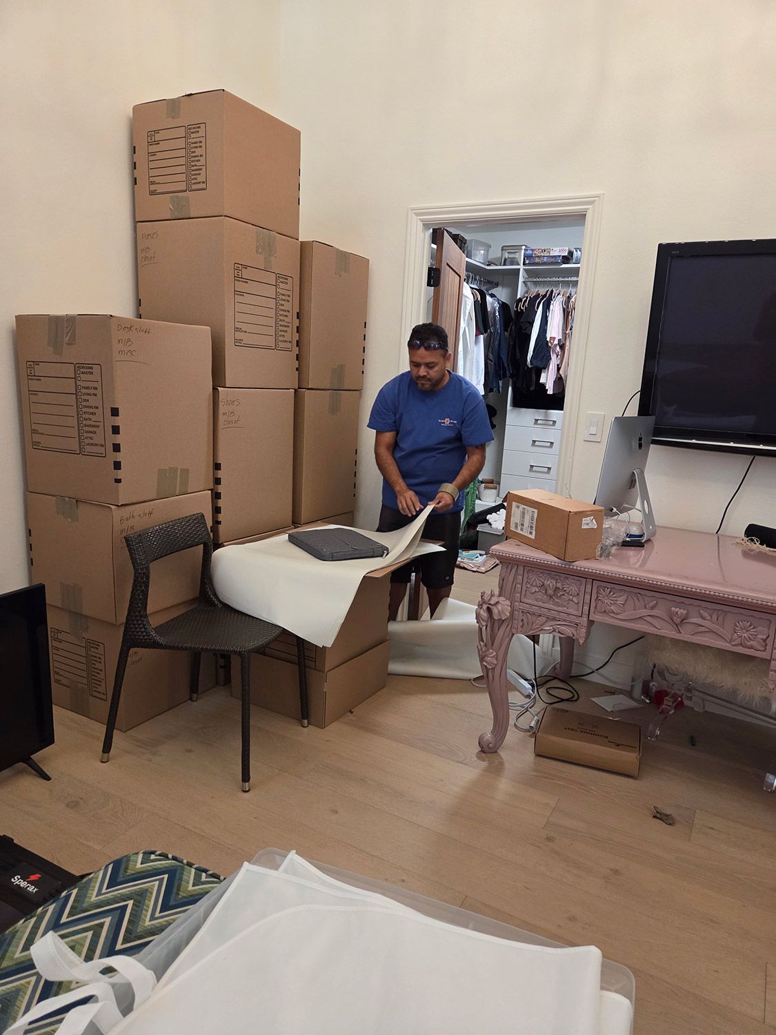 Person moving a white cushioned chair in a room