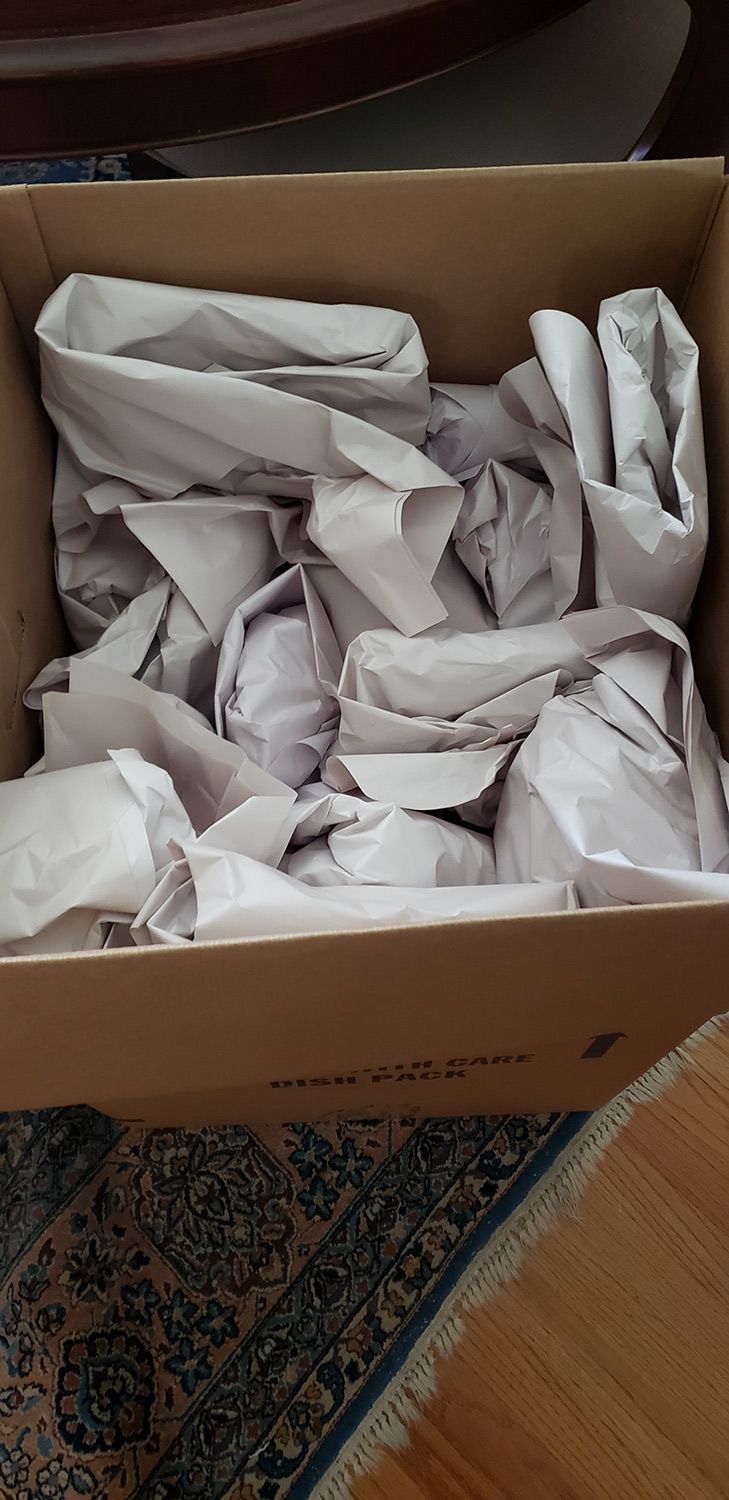 Cardboard box filled with crumpled white packing paper