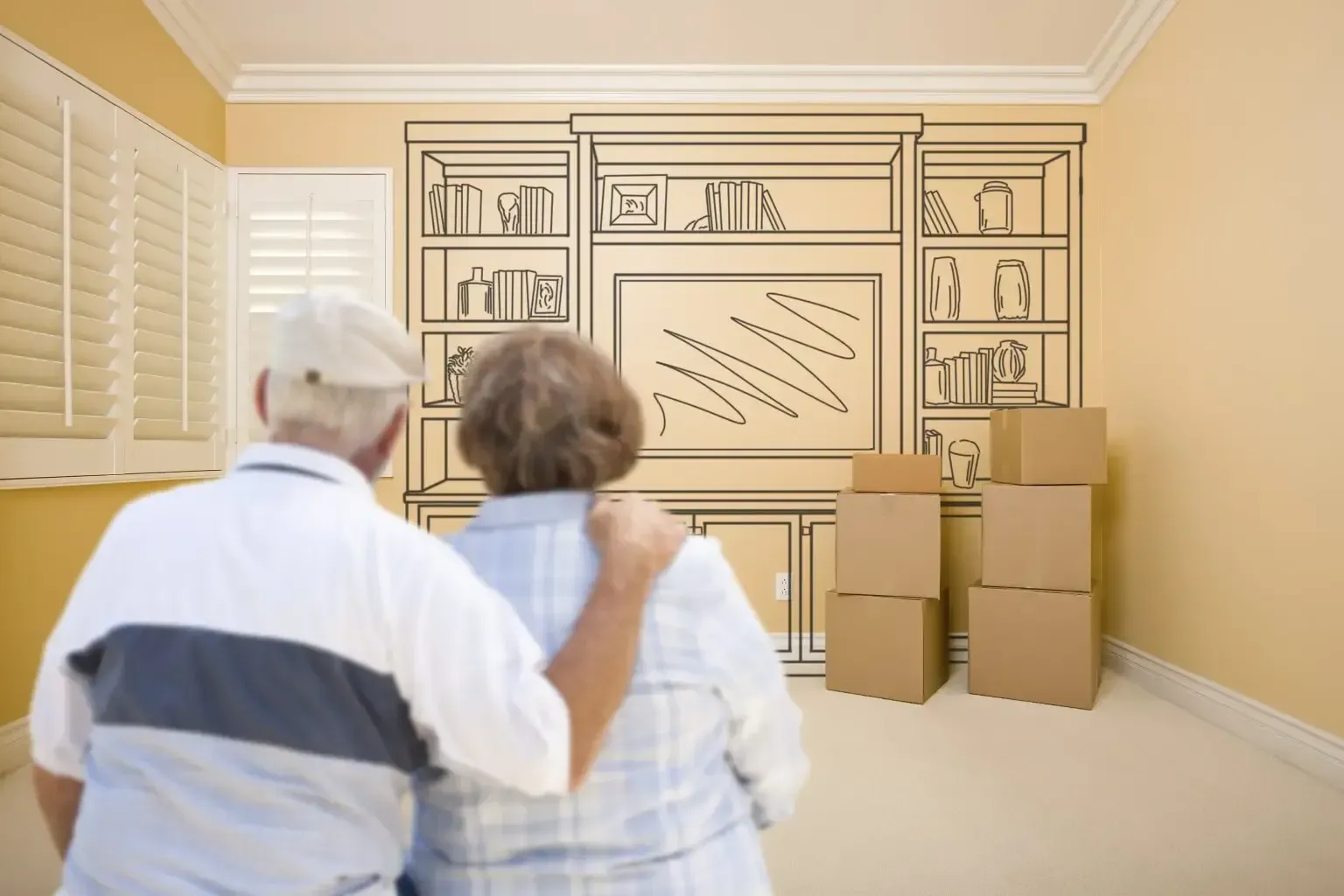 Two senior people and moving boxes in a room