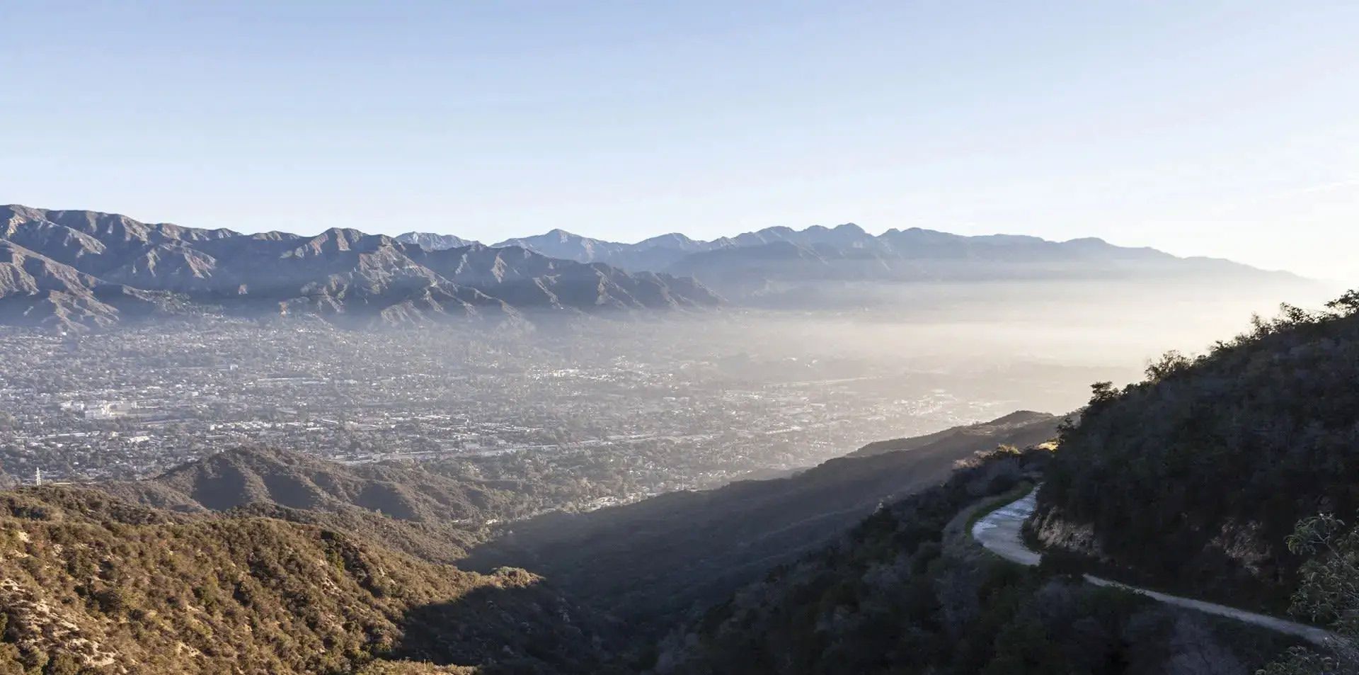 Panoramic mountain valley with hazy city below