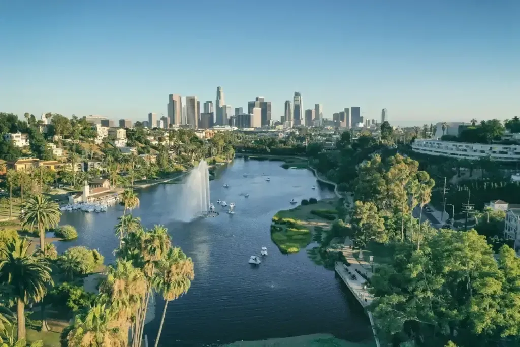 Aerial view of a river through lush parkland with a city skyline