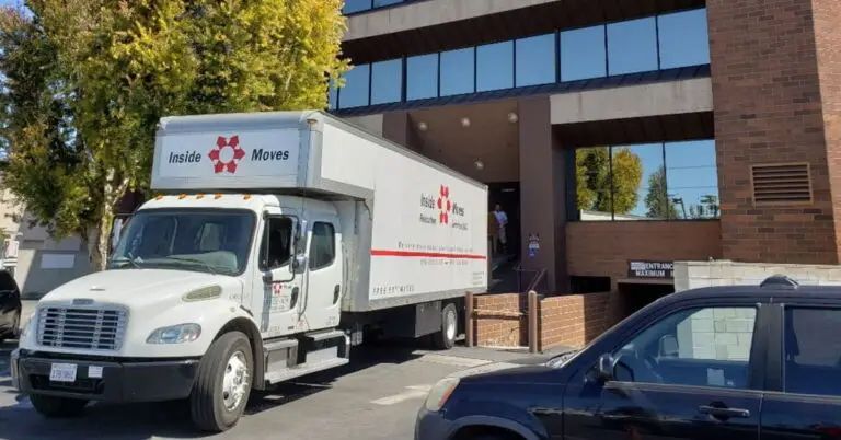 Moving truck parked outside a brick office building