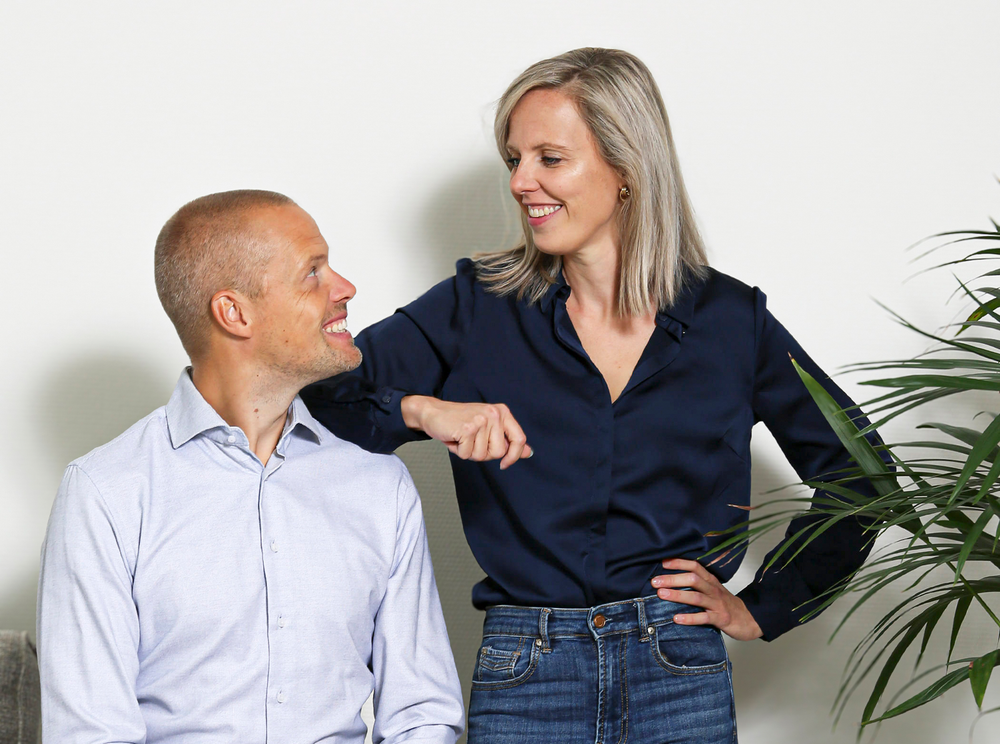 Twee collega’s die lachend met elkaar in gesprek zijn.