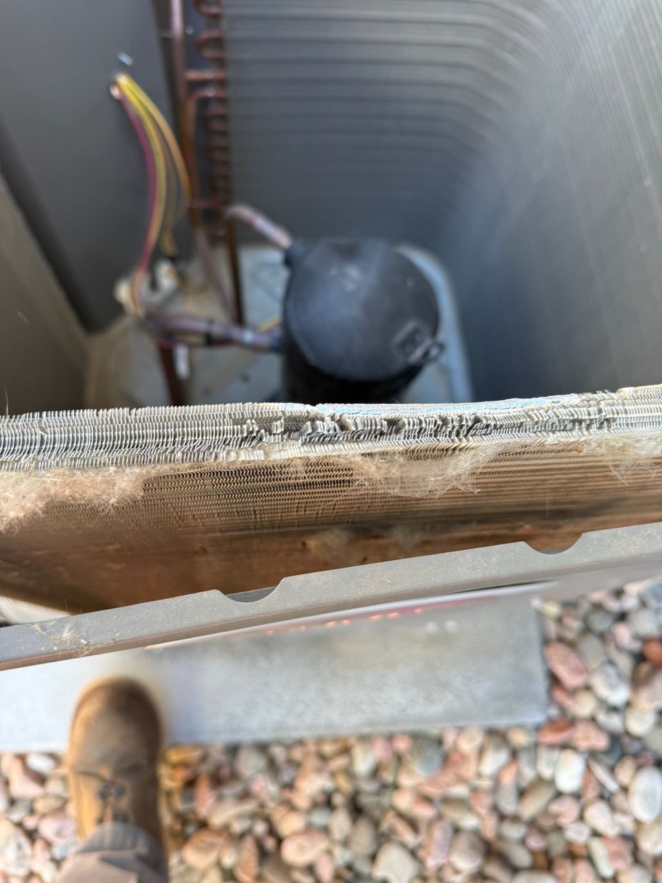 Open HVAC unit with visible wiring and a black compressor inside, viewed from above