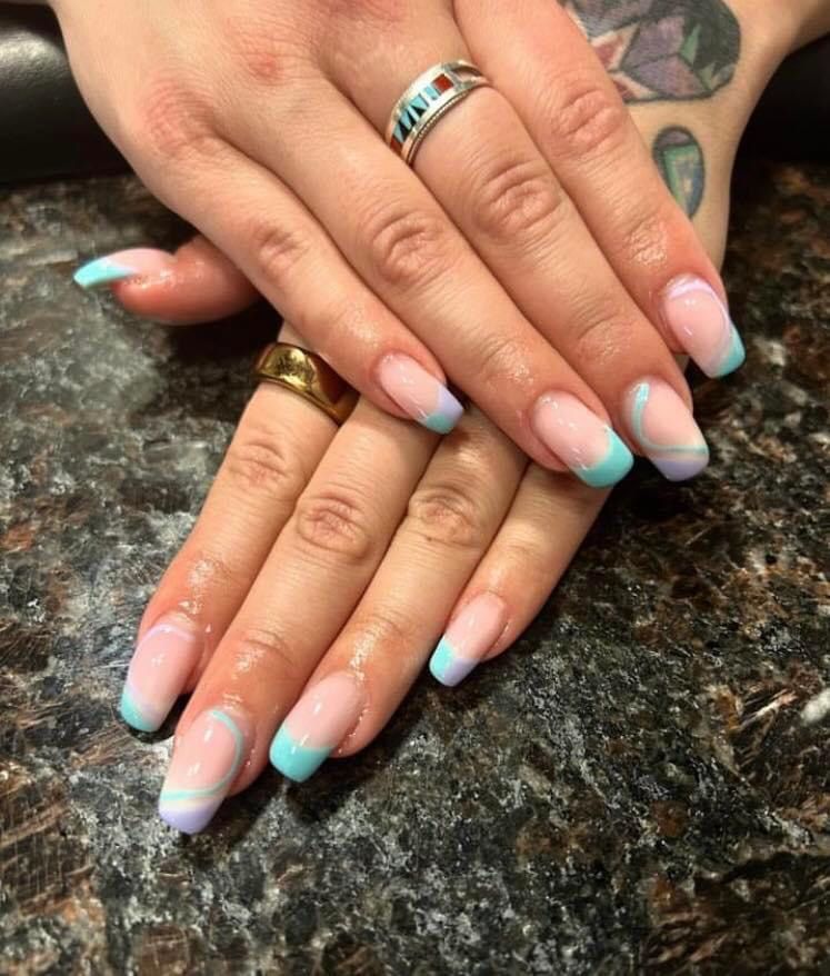 A close up of a woman 's nails with a ring on her finger