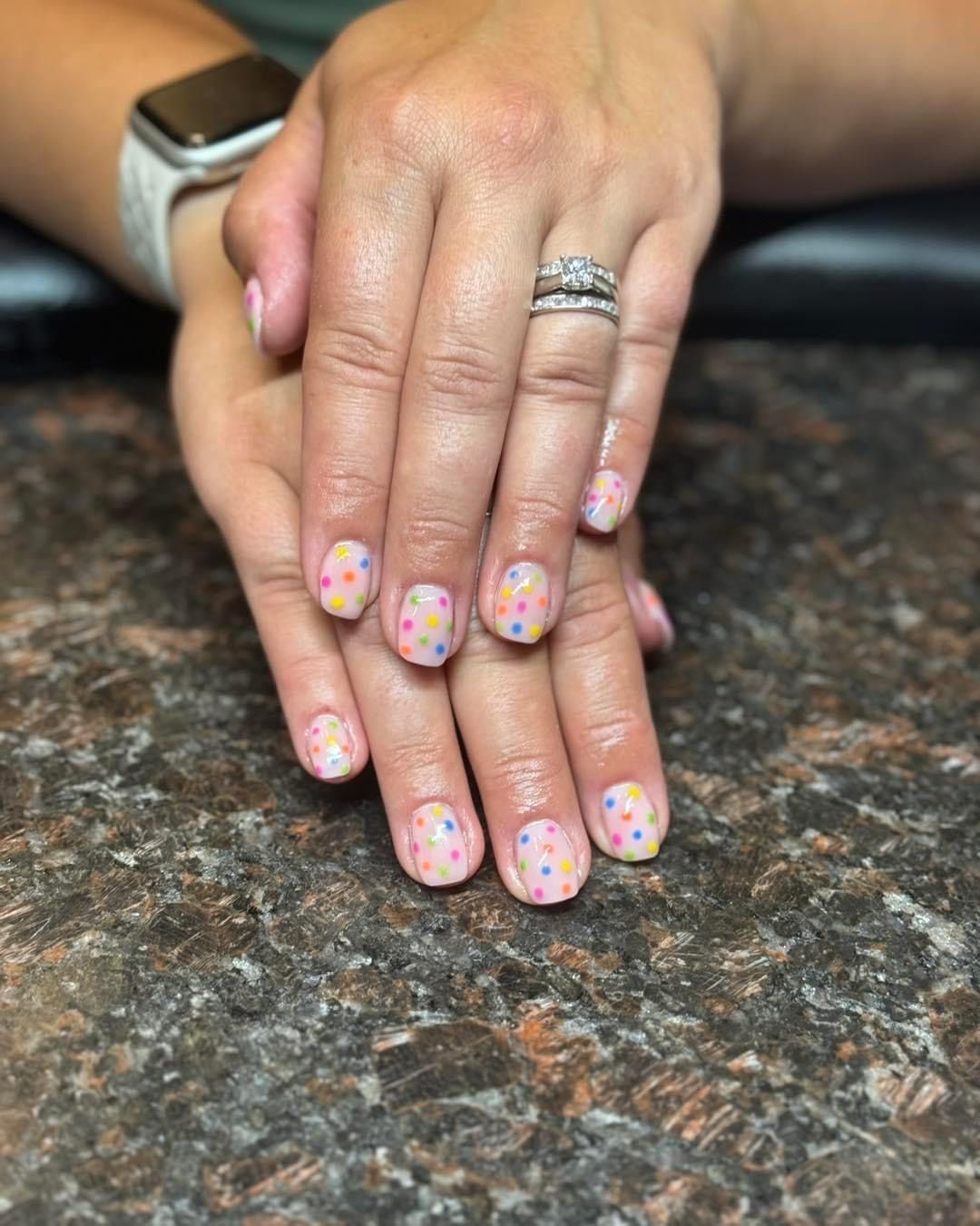A close up of a woman 's nails with a ring on her finger.