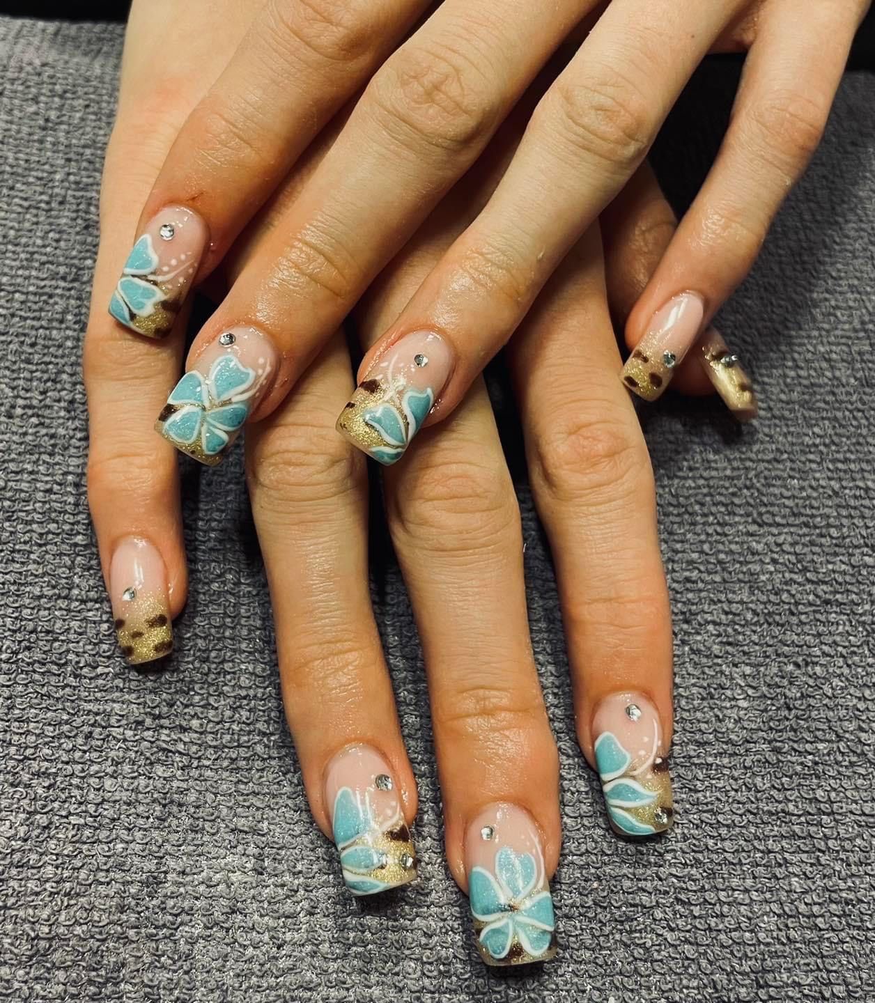 A woman 's nails are decorated with flowers and leopard print