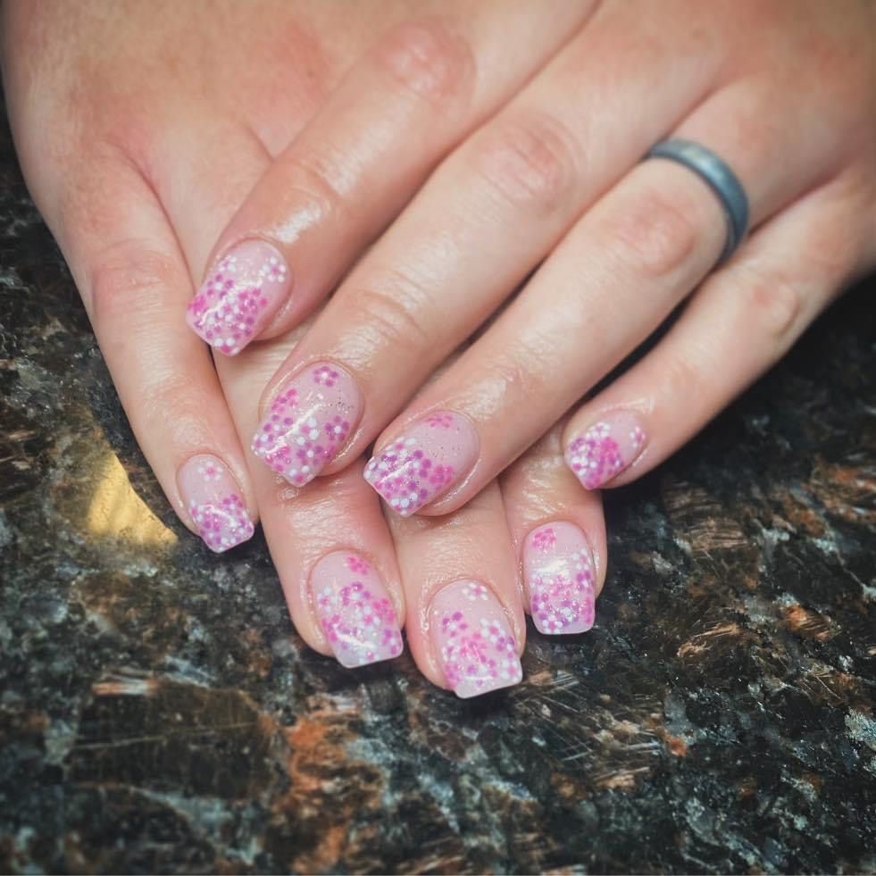 A woman 's hands with pink nails and a ring on her finger