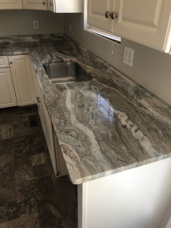 Kitchen countertop with marbled granite finish and an undermount sink, viewed from above