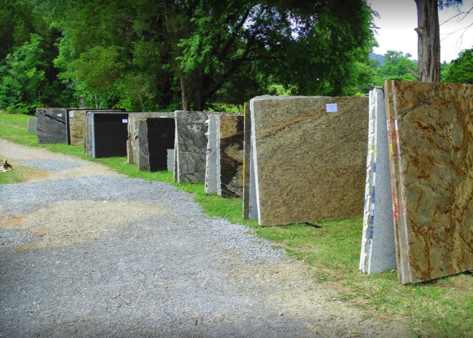 Rows of upright granite slabs along a gravel path in a green outdoor setting