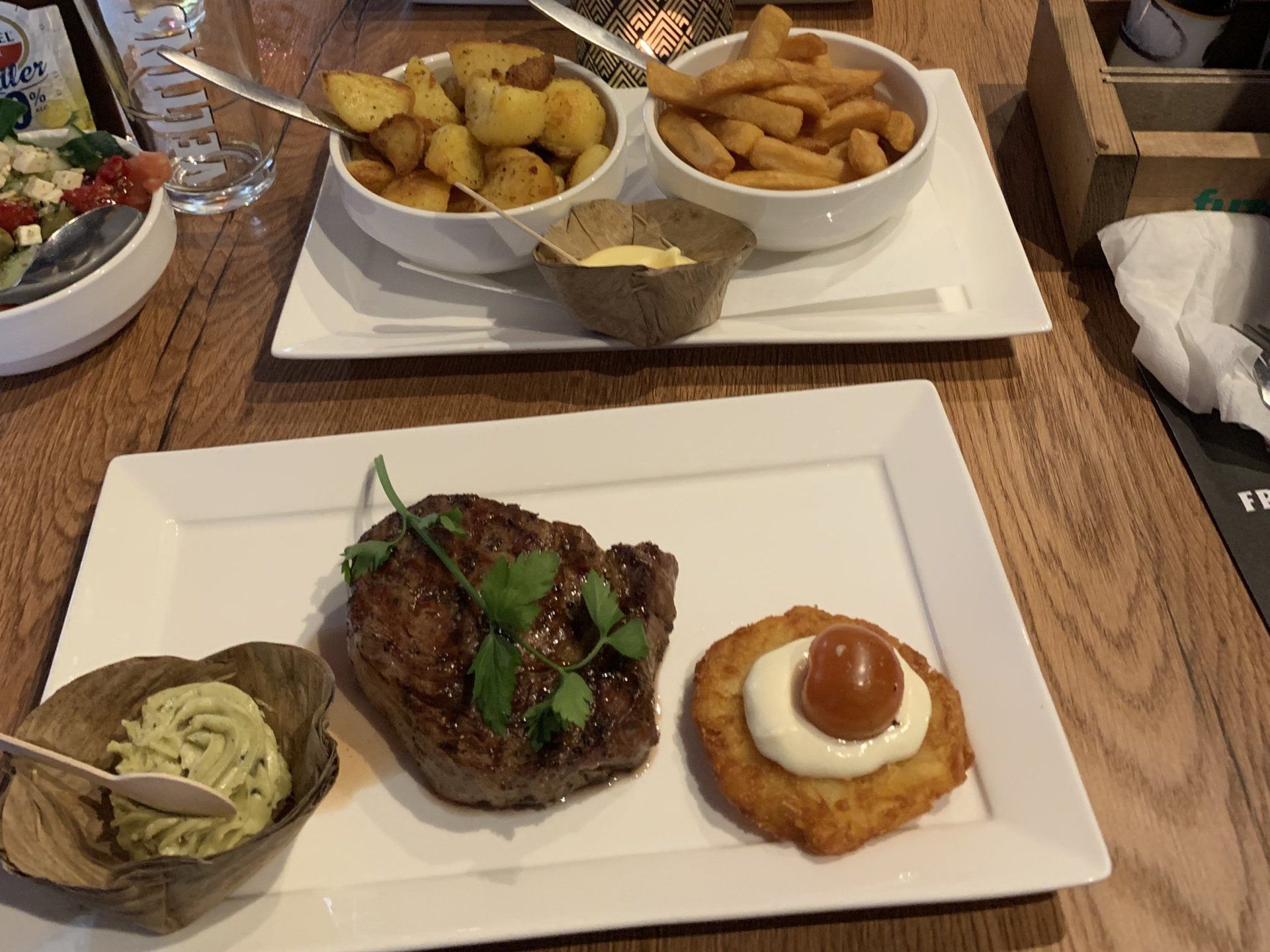 Een biefstuk met aardappelen en saus als bijgerecht op een tafel in een restaurant.
