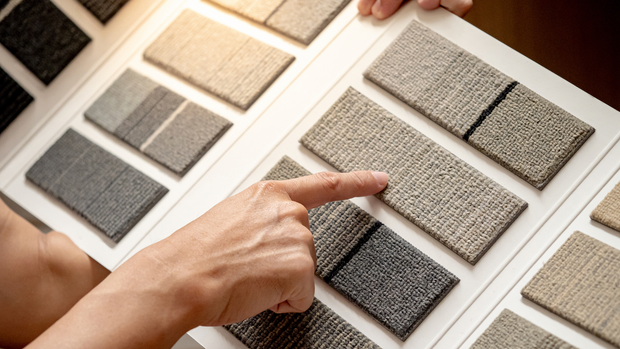 A person is pointing at a piece of carpet.