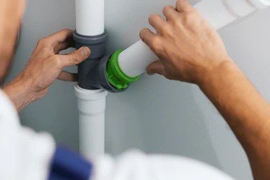 A Person is Connecting White Pvc Pipes Using a Black T-Connector — David Lewis Solahart in Kyogle, NSW