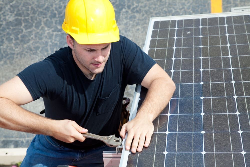 A Man Wearing A Hard Hat Is Working On A Solar Panel — David Lewis Solahart in Evans Head, NSW