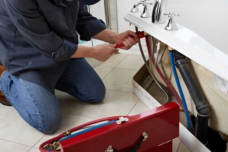 Plumber Kneeling by a Bathtub, Using a Wrench on Pipes — David Lewis Solahart in Evans Head, NSW