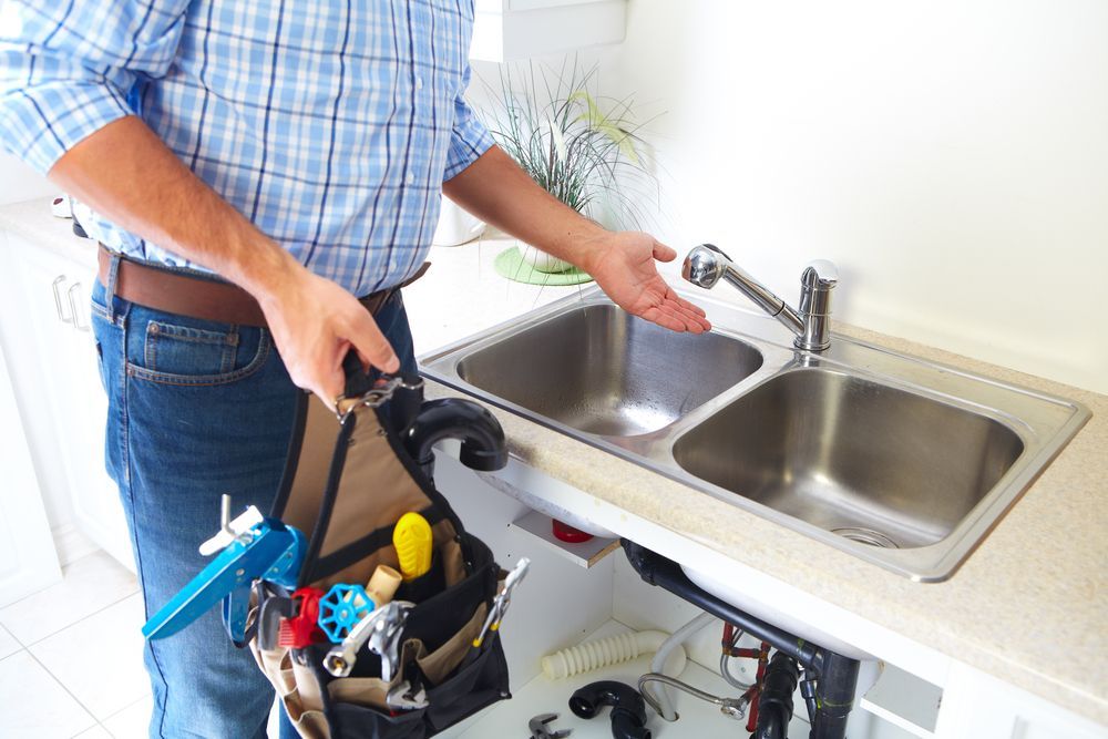 A Plumber is Fixing a Sink in a Kitchen — David Lewis Solahart in Goonellabah, NSW