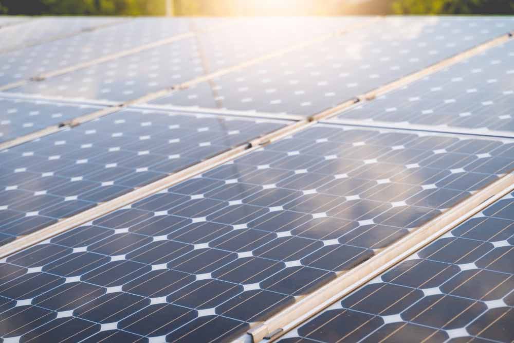A Row Of Solar Panels On A Roof With The Sun — Solahart In Goonellabah, NSW