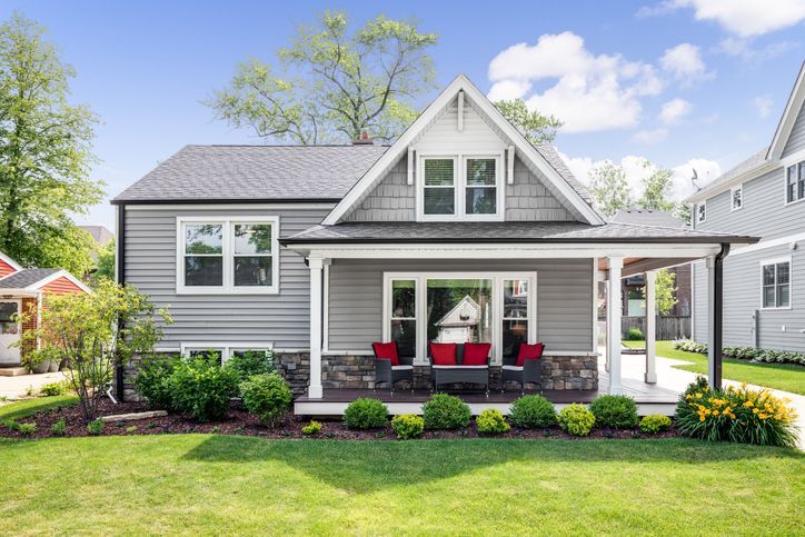 A grey modern farmhouse with a covered porch.