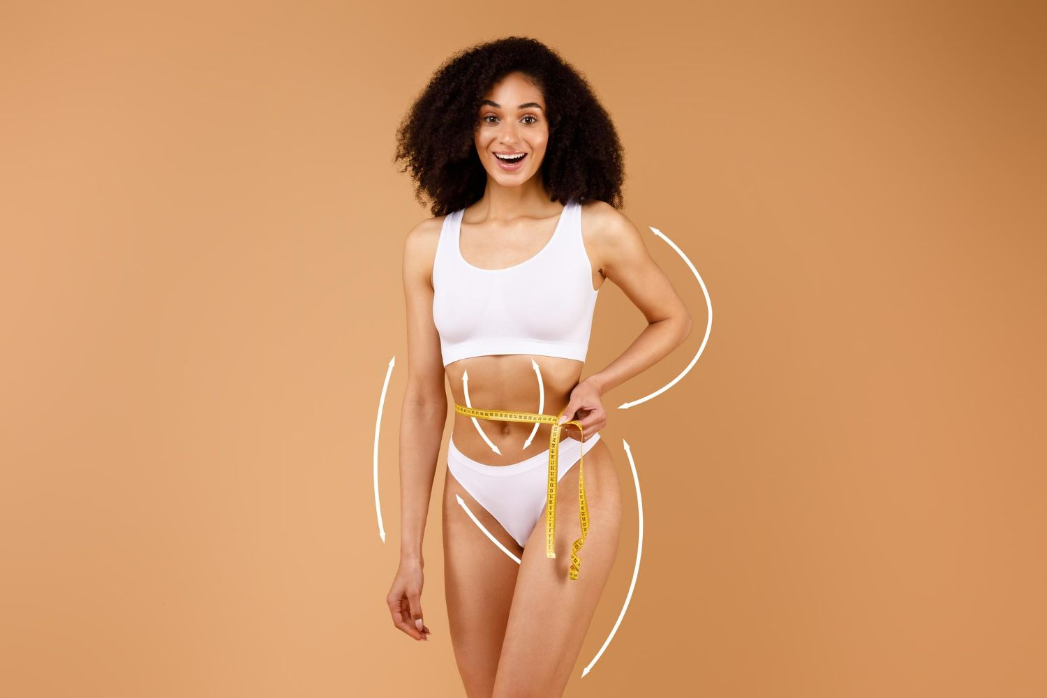 A smiling person in white athletic wear holds a yellow measuring tape around their waist against a tan background.