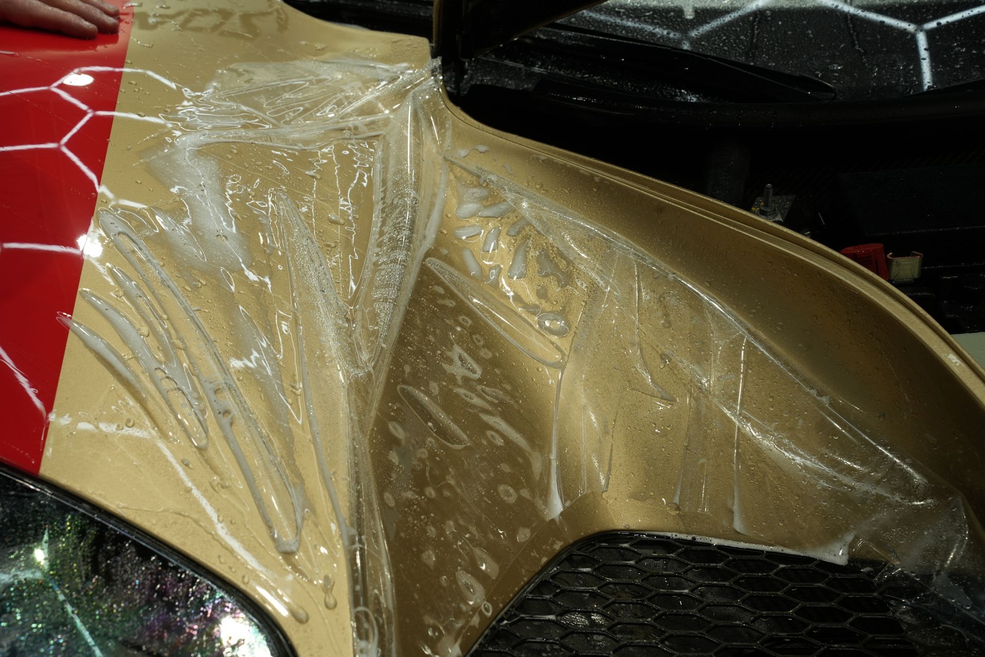 A close-up of a gold car covered in PPF