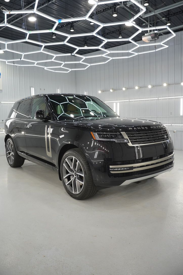 Black SUV in a bright showroom under geometric ceiling lights