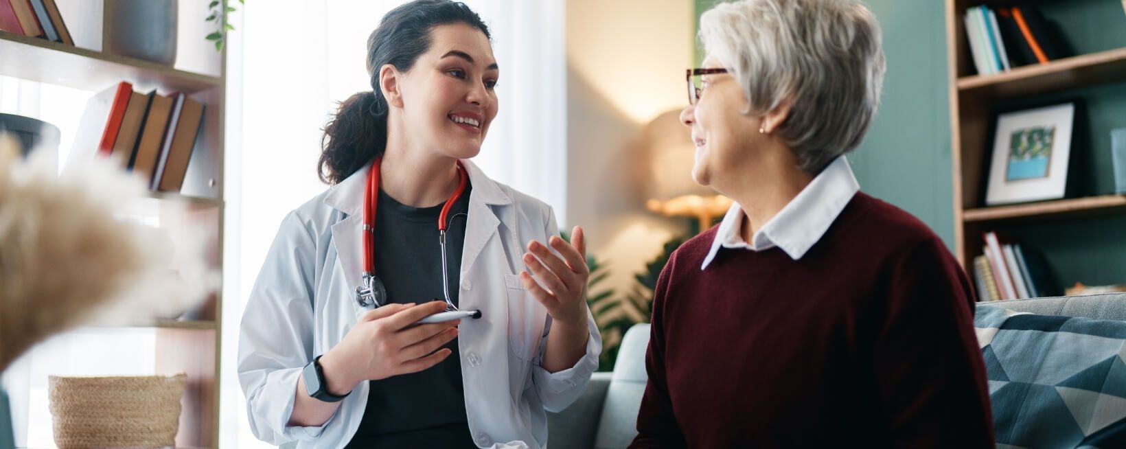 Do I Need Mobile Wound Care or Home Health? Banner. Clinician speaking with a patient in her home.
