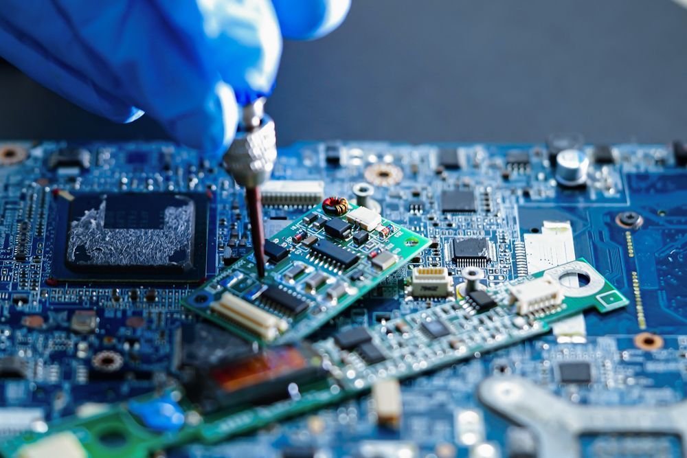 Gloved Hand Using a Screwdriver to Repair a Circuit Board — Rescuetech Computer And iPhone Repairs in Byron Bay, NSW