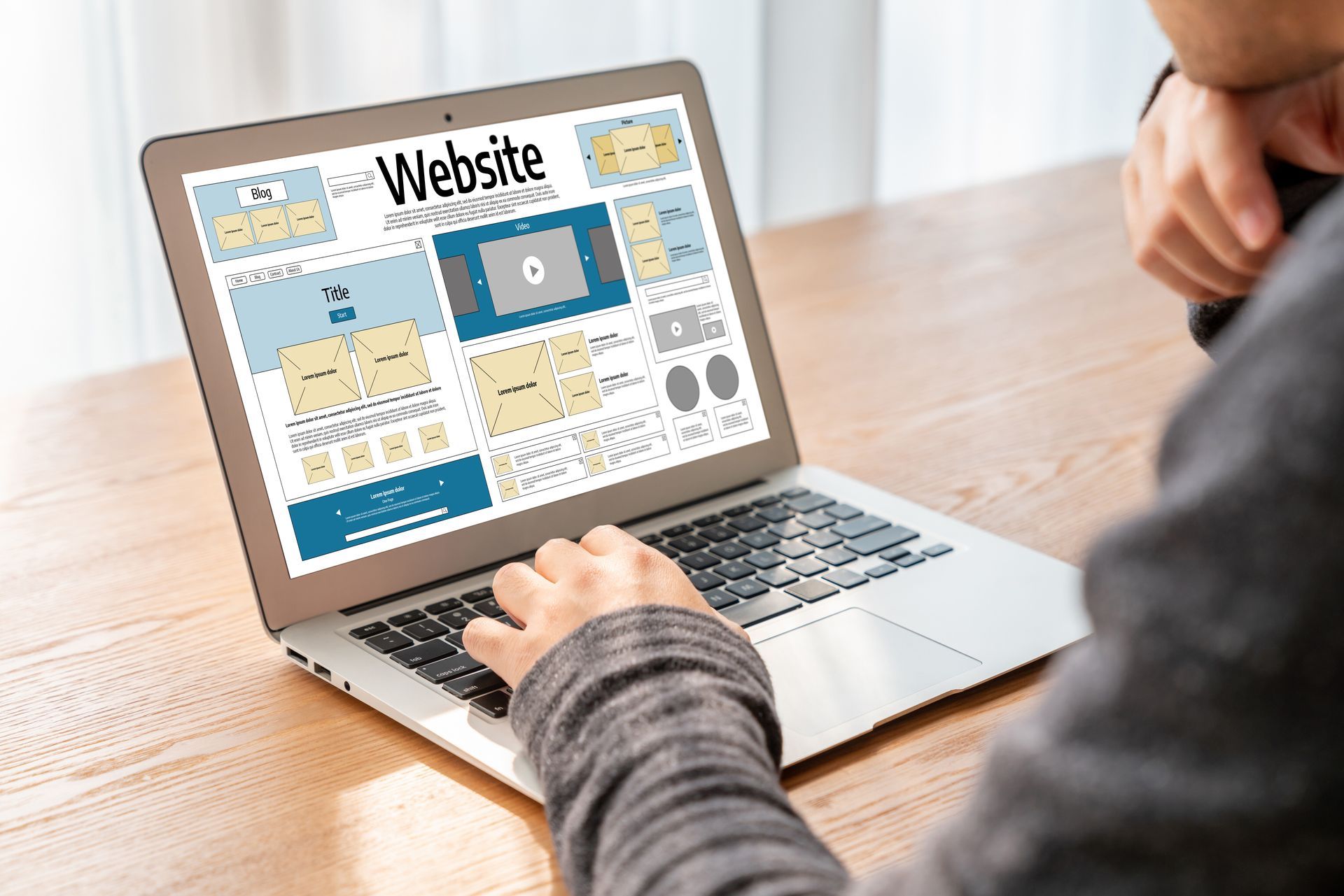 Person Using a Laptop Displaying a Website Wireframe — Rescuetech Computer And iPhone Repairs in Lennox Head, NSW